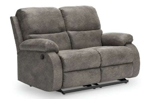 Un loveseat reclinable de color gris, con cojines mullidos y base de metal negro, que se muestra sobre un fondo blanco liso.