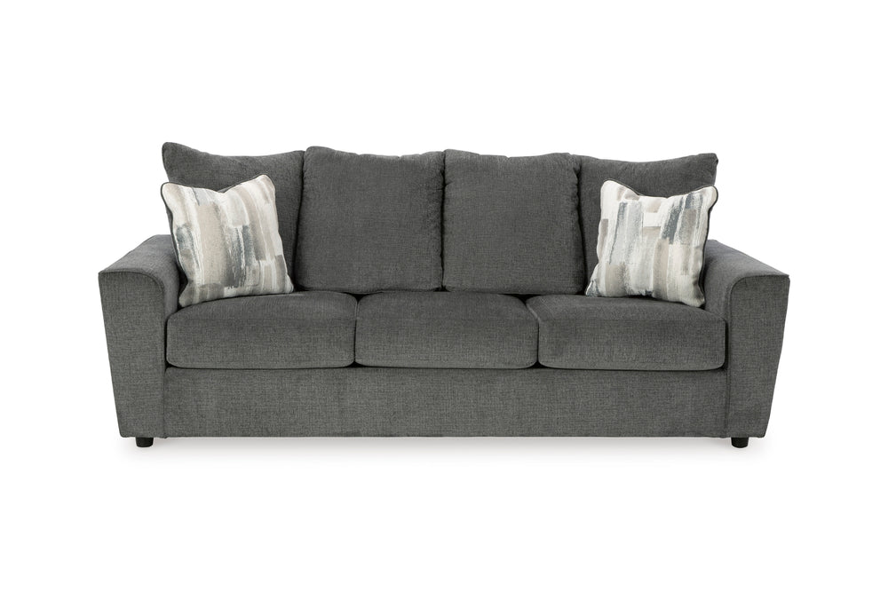 Sofá gris con cojines estampados sobre fondo blanco.