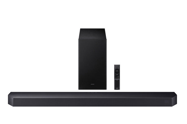 Barra de sonido negra con control remoto sobre fondo blanco. 