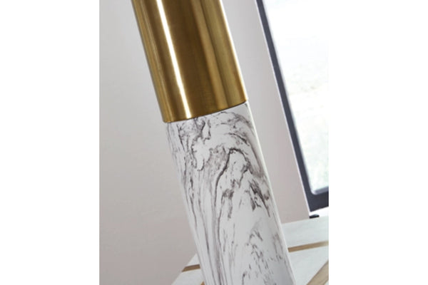 Lápiz labial con tapa dorada y estampado de mármol sobre fondo blanco.