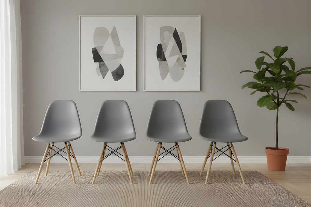 Cuatro sillas blancas con patas de madera dispuestas en fila contra una pared gris con arte abstracto y una planta.