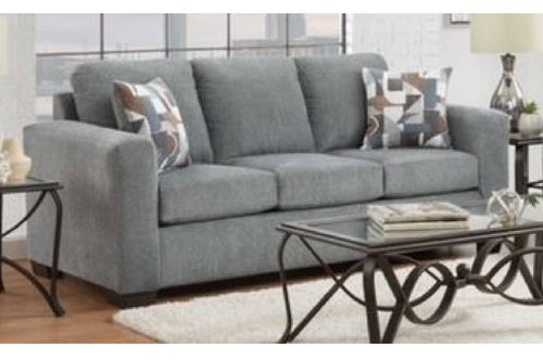 Sofá de color gris con objetos decorativos en una sala. 