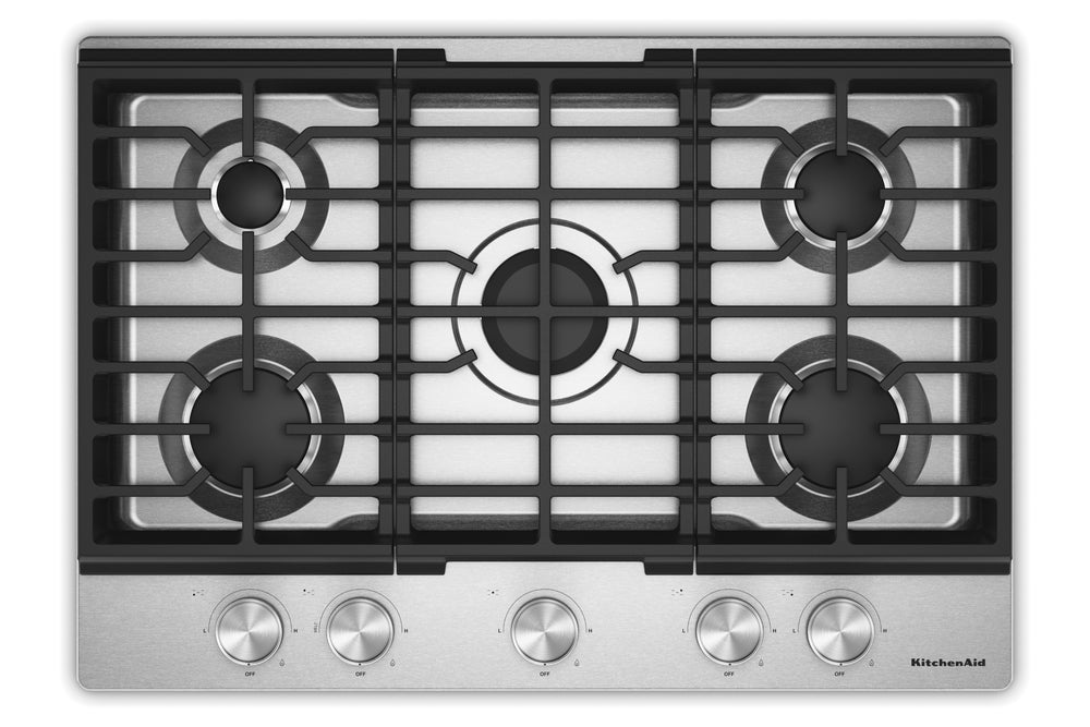 Un tope de cocina de gas de 5 quemadores con rejilla de hierro fundido negro y panel de control de acero inoxidable con cinco perillas plateadas, mostrada sobre un fondo blanco.