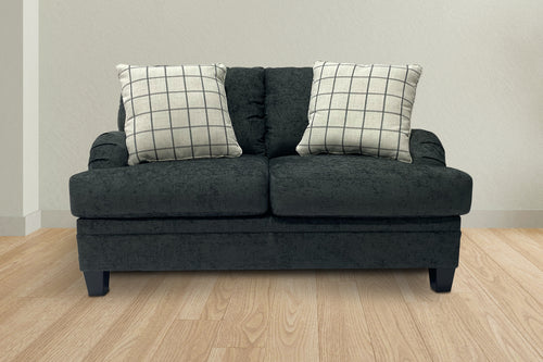 Loveseat de color verde oscuro con cojines decorativos en una sala neutral. 