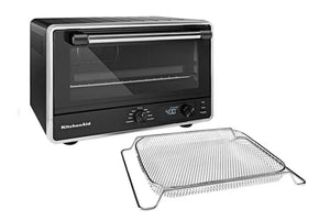 Horno de sobremesa KitchenAid en color negro y plateado con puerta de cristal, que se muestra junto a una rejilla de alambre de acero inoxidable sobre un fondo blanco.
