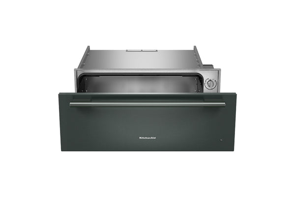 Cajón calentador KitchenAid de 30 pulgadas en color verde con acabado mate, mostrado parcialmente abierto para revelar el compartimento interior de acero inoxidable y la perilla de control lateral, sobre fondo blanco.