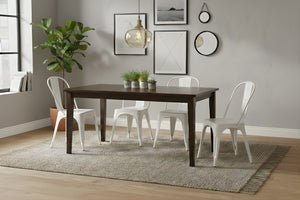Mesa rectangular de madera marrón oscuro con cuatro sillas blancas en un ambiente de sala. 