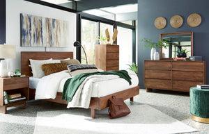 Dormitorio contemporáneo con cama de madera, mesa de noche, cómoda con espejo y cajonera alta a juego. La habitación incluye ropa de cama blanca, detalles decorativos en tonos verdes, arte mural y amplios ventanales que aportan luz natural.