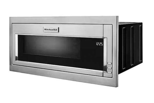 Horno microondas empotrable KitchenAid con exterior de acero inoxidable y puerta de cristal negro, que se muestra parcialmente empotrado en la pared con su panel lateral extendido.