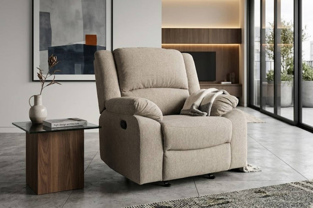 Una butaca reclinable tapizado en color beige con un cojín a juego, que se muestra en un salón moderno junto a una mesa auxiliar de madera.