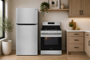 Una escena de cocina moderna que muestra una nevera LG con congelador superior, junto a una cocina de gas con horno a juego, también en acero inoxidable y negro.