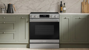 Una estufa eléctrica Samsung con puerta de cristal negro y controles de acero inoxidable, ubicada entre gabinetes de cocina verde con tope de mármol.
