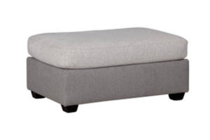 Ottoman rectangular con acolchado gris claro y gris oscuro con patas acabadas en marrón, todo sobre un fondo blanco. 