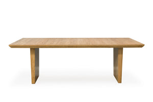Una mesa rectangular de madera con un acabado en roble claro, que cuenta con un tablero grueso y dos patas cónicas en forma de bloque, mostrada sobre un fondo blanco liso.