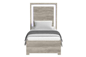 Cama de color gris claro y blanco con acolchado sobre un fondo blanco. 