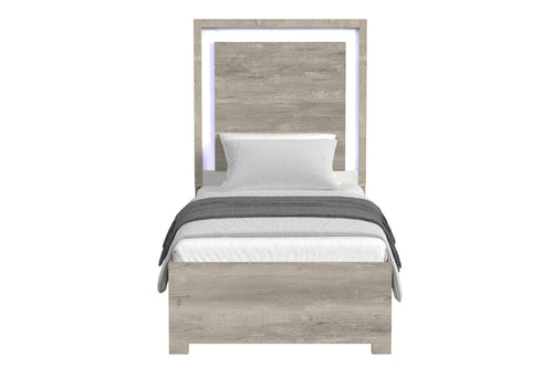 Cama de color gris claro y blanco con acolchado sobre un fondo blanco. 