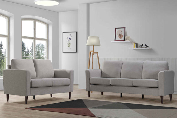 Sofá y loveseat de color gris en una sala con objetos decorativos. 