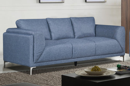 Sofá azul claro con patas metálicas en una sala con objetos decorativos. 