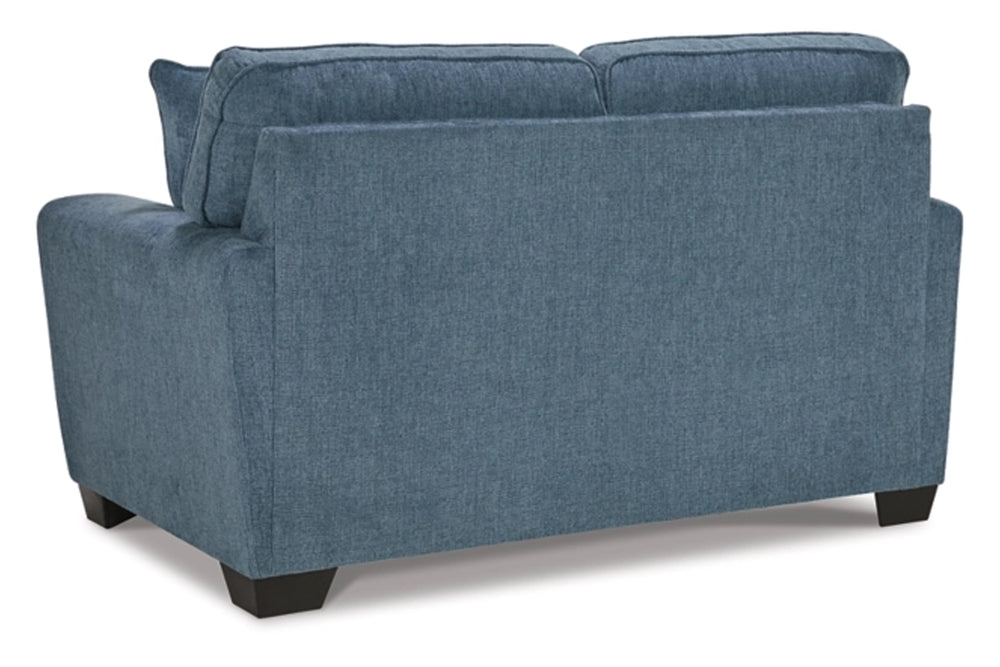 Loveseat de color azul con cojines sobre un fondo blanco. 