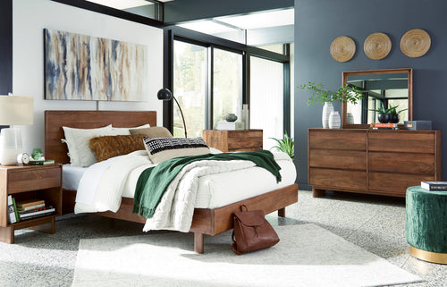 Dormitorio contemporáneo con cama de madera, mesa de noche, cómoda con espejo y cajonera alta a juego. La habitación incluye ropa de cama blanca, detalles decorativos en tonos verdes, arte mural y amplios ventanales que aportan luz natural.