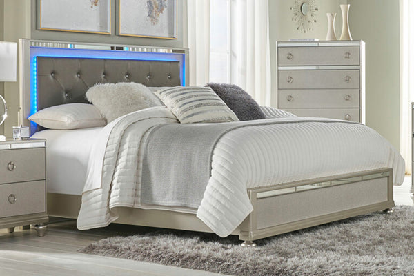 Cama tapizada con acentos dorados con acolchado blanco en una habitación moderno con elementos decorativos. 