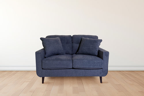 Loveseat de color azul con patas acabadas en marrón en una sala neutral. 