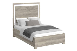 Cama de color gris claro y blanco con acolchado sobre un fondo blanco. 