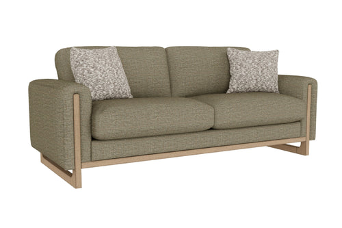 Sofá de color verde con dos cojines decorativos sobre un fondo blanco. 