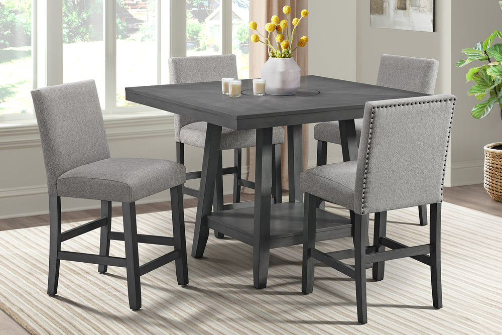 Mesa cuadrada de color gris oscuro con cuatro taburetes con acolchado gris claro y con reposapiés y respaldar en un fondo blanco. 