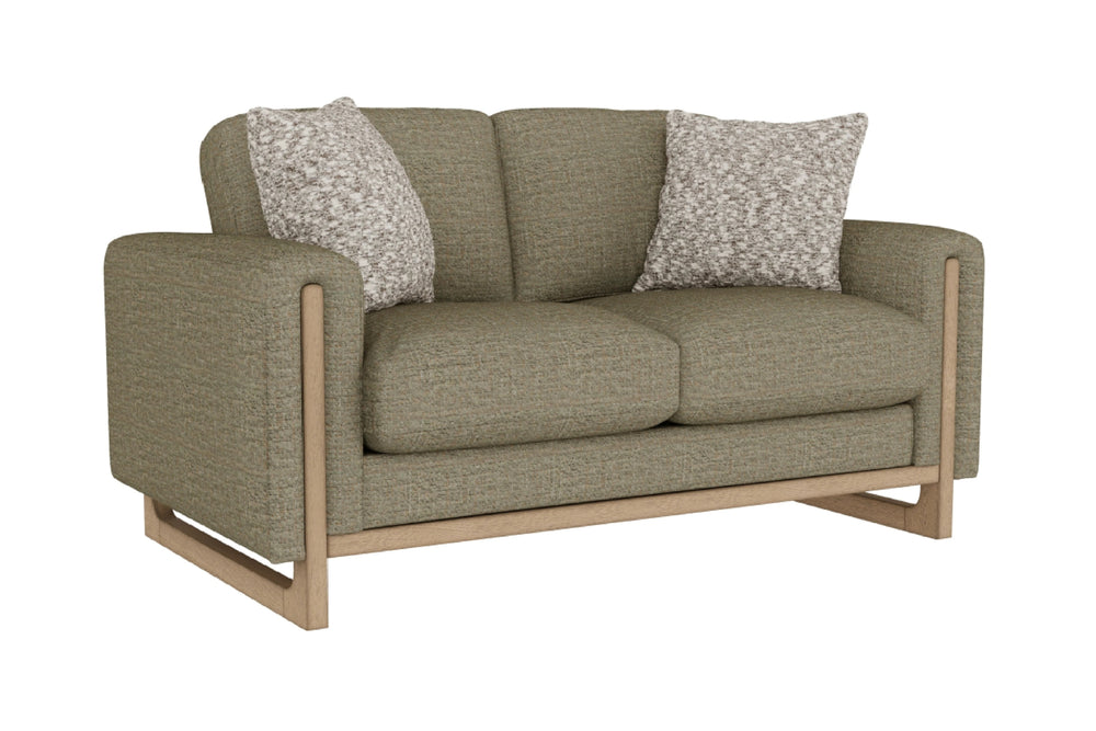 Loveseat de color verde con dos cojines decorativos sobre un fondo blanco. 