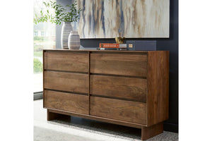 Gavetero de seis gavetas hecho de madera marrón en un entorno de habitación iluminada con objetos decorativos. 