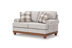 Loveseat gris con cojines a cuadros sobre fondo blanco.