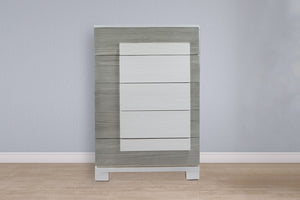 Chest de cinco gavetas de color gris en una habitación neutral. 