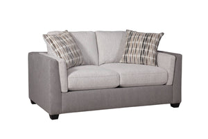 Loveseat de dos plazas tapizado en tela bicolor gris y beige, con cojines de asiento y respaldo amplios y acolchados. Incluye dos cojines decorativos con patrón abstracto en tonos neutros. Cuenta con apoyabrazos rectos y patas bajas oscuras, presentado sobre fondo blanco con vista en ángulo que muestra el lateral.