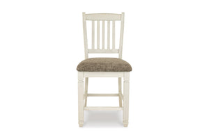 Una silla de comedor clásica de madera con estructura pintada en color blanco roto con efecto envejecido y cojín de asiento tapizado en color topo texturizado, mostrada sobre un fondo blanco liso.