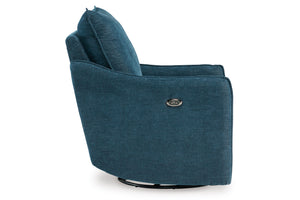 Sillón giratorio moderno tapizado en tela texturizada azul, visto desde un ángulo lateral sobre fondo blanco.
