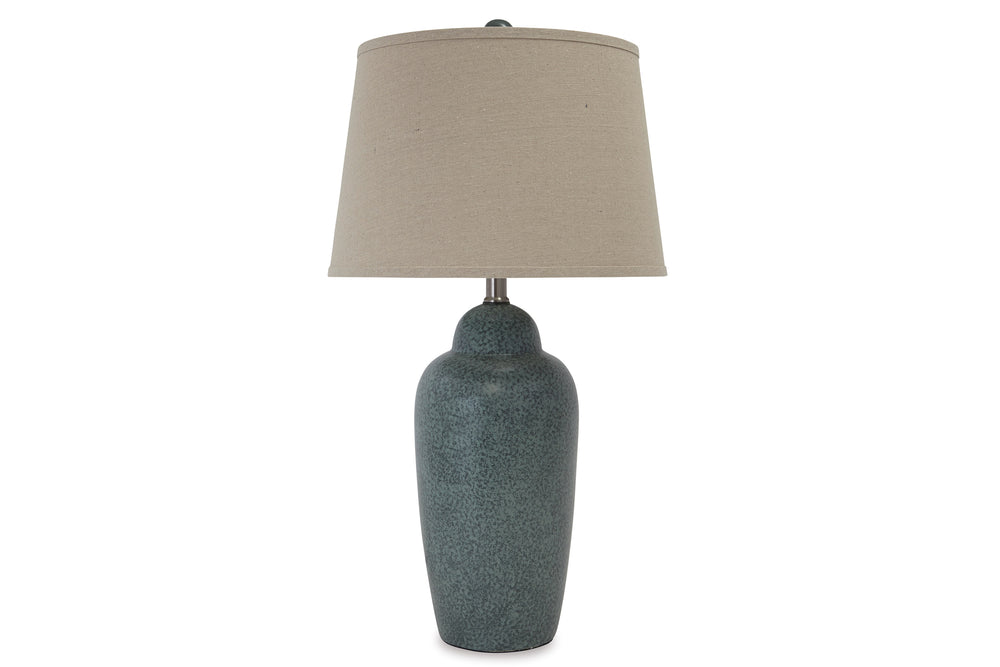 Lámpara de sobremesa con base azul texturizada y pantalla beige sobre fondo blanco.