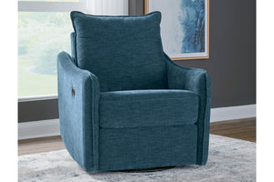 Sillón giratorio tapizado en azul turquesa con cojín de respaldo, en una sala decorada con ventana, pared gris, cuadro y alfombra clara.