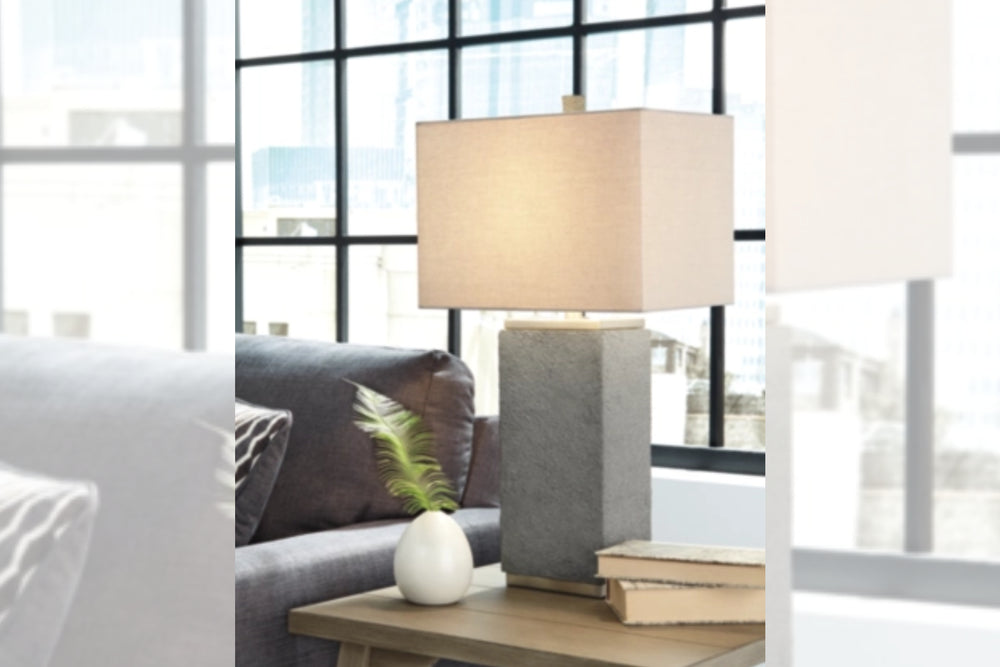 Lámpara de mesa con base gris texturizada y pantalla rectangular blanca sobre fondo blanco