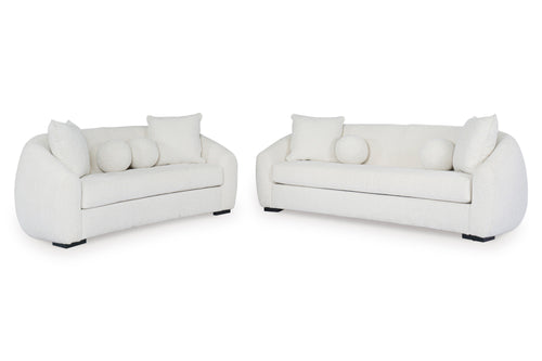 Sofá y loveseat de color blanco con cojines sobre un fondo blanco. 