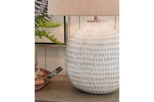 Lámpara de mesa texturizada sobre superficie de madera con fondo difuminado.