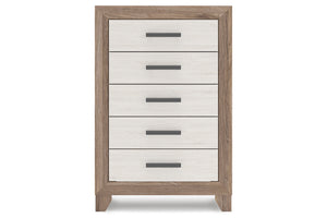 Un chest de 5 cajones con estructura de veta de madera clara y frentes de cajón blancos, con tiradores de barra horizontal en gris oscuro, presentado sobre un fondo blanco uniforme.