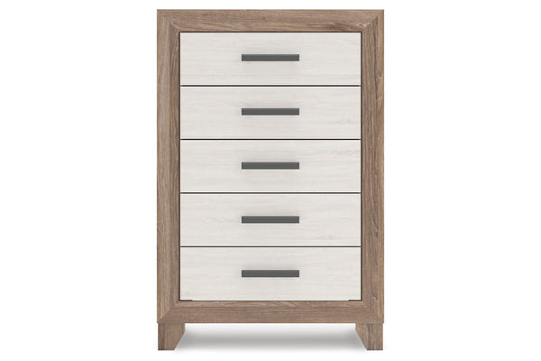 Un chest de 5 cajones con estructura de veta de madera clara y frentes de cajón blancos, con tiradores de barra horizontal en gris oscuro, presentado sobre un fondo blanco uniforme.