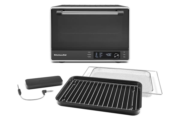 Horno de convección de sobremesa KitchenAid en color negro y acero inoxidable, que se muestra con una bandeja negra, una rejilla metálica y un termómetro digital con sonda sobre un fondo blanco.