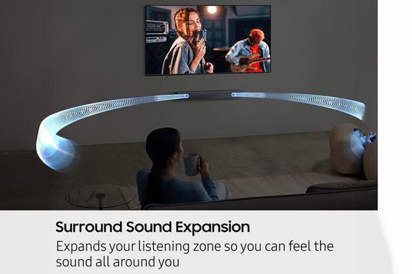 Persona viendo televisión con barra de sonido curva en una sala. 