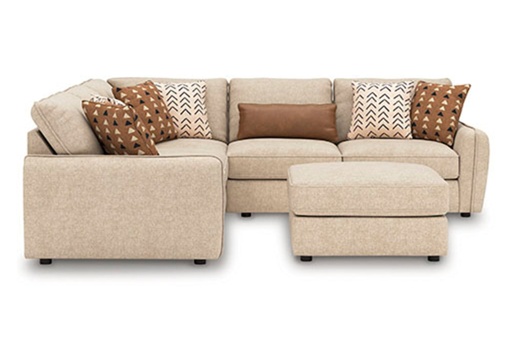 Seccional con ottoman de color beige y con cojines naranjas y blancas decorativas sobre un fondo blanco. 