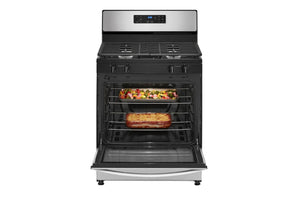 Estufa de gas de acero inoxidable con comida en el horno sobre un fondo blanco.