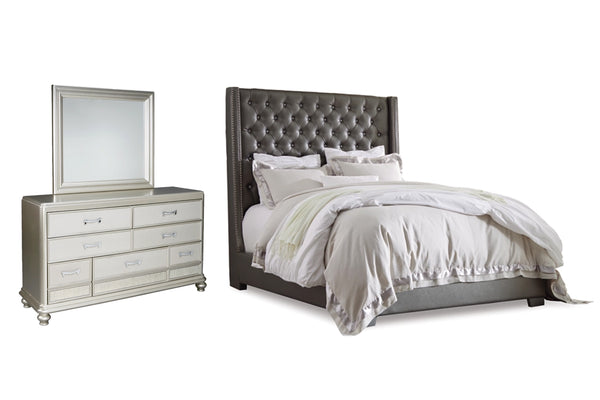 Conjunto de dormitorio gris que incluye una cama capitoné y un gavetero con espejo sobre fondo blanco.