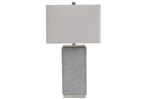 Lámpara de mesa con base gris texturizada y pantalla rectangular blanca sobre fondo blanco