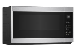 Un horno microondas KitchenAid para instalar sobre la encimera, con exterior de acero inoxidable y puerta de cristal negro, mostrado desde un ángulo de tres cuartos sobre un fondo blanco.